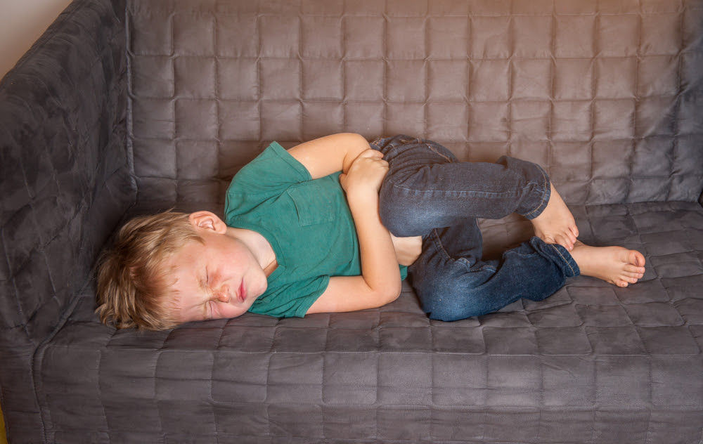 Depicting a child suffering from chronic pain on a couch.