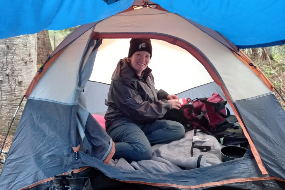 Image of pancreatitis patient Megan in a grey and orange tent in a campground.