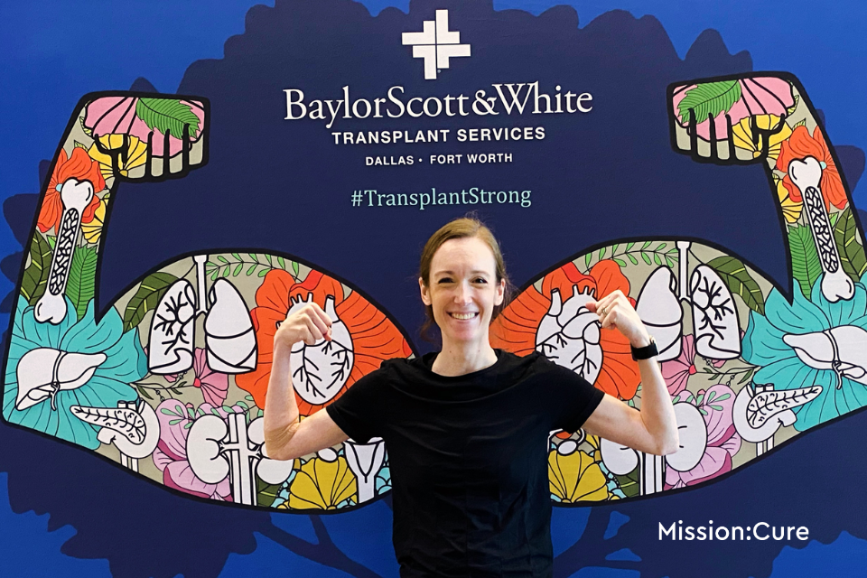 Woman standing with her arms flexed matching a mural behind her.